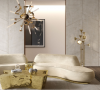 A living room with a netral tones with a gold modern coffee table, a nude, cream sofa and a chandelier gold.