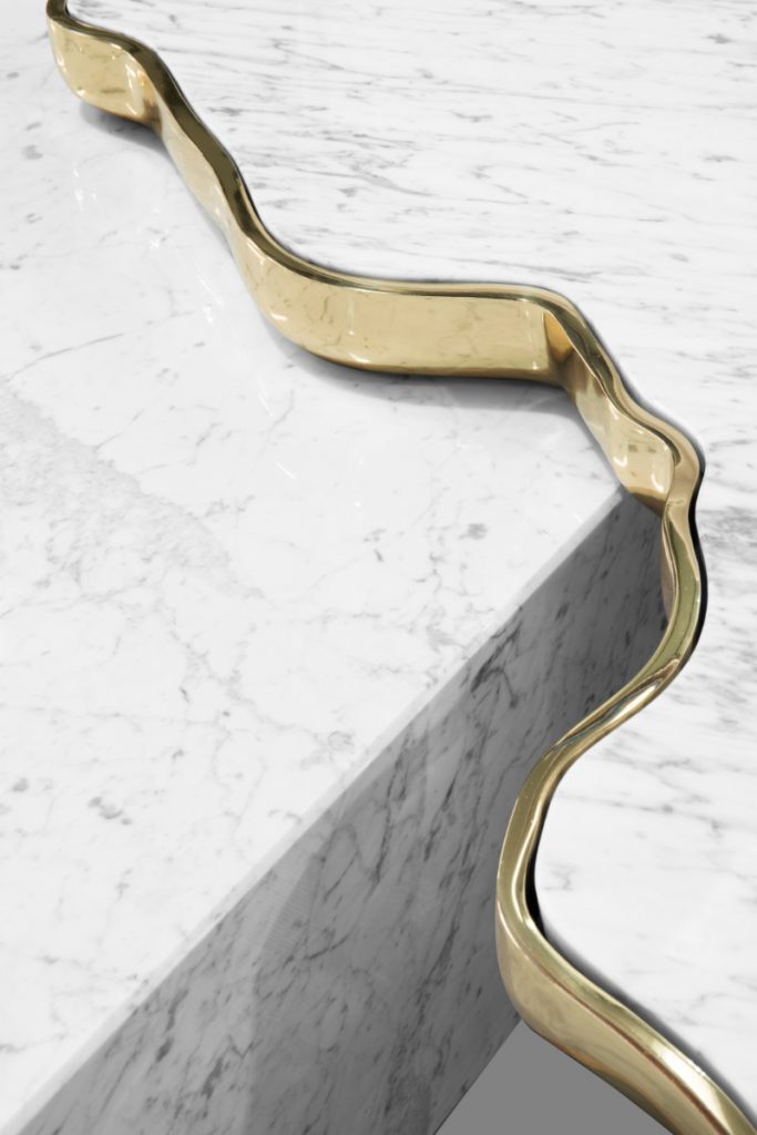 A modern coffee table in a marble texture and gold details.