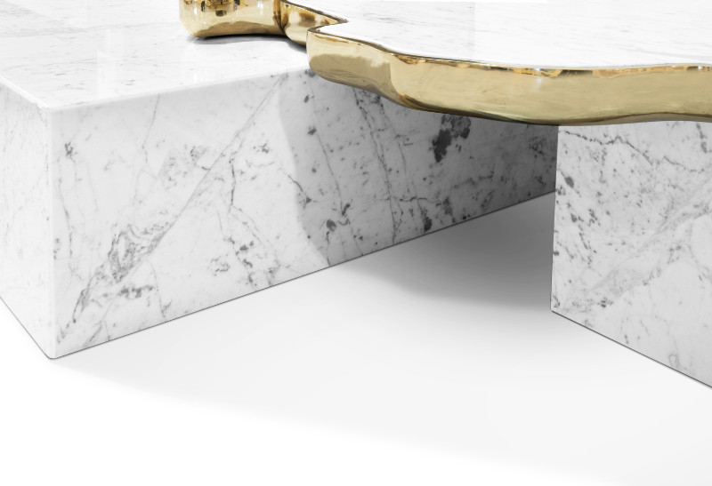 A modern coffee table in a marble texture and gold details.